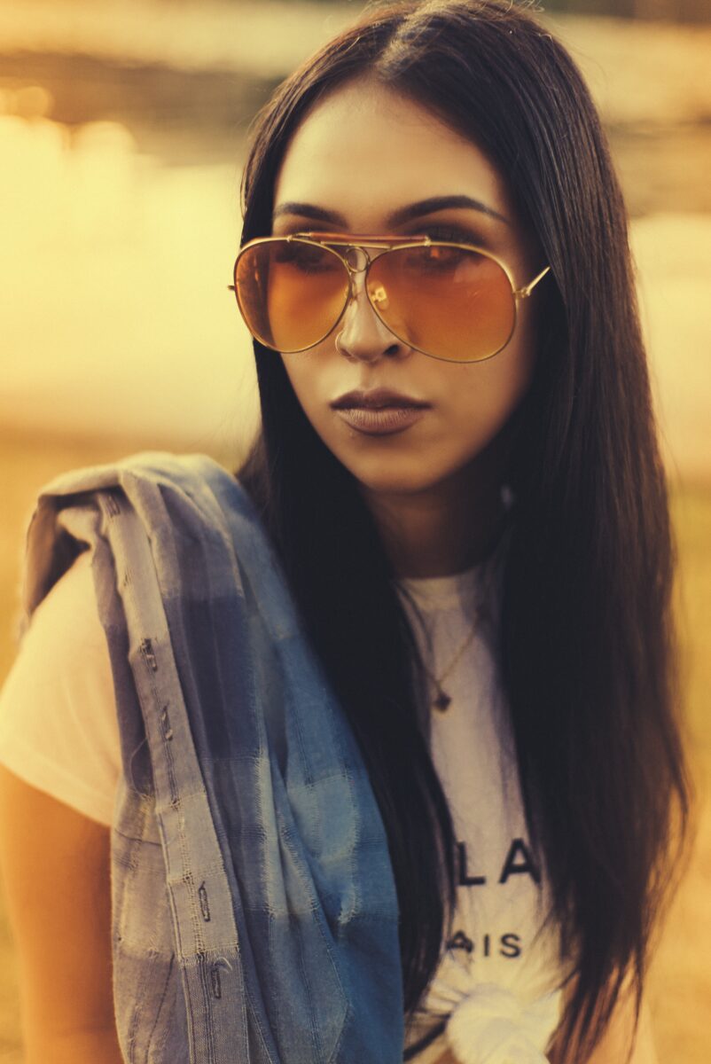 Portrait of a woman in tinted aviator sunglasses in golden evening light