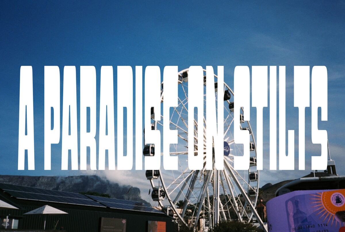 Poster reading A Paradise on Stilts in heavy white type over a Ferris wheel and blue sky